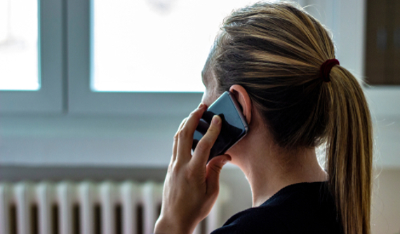 Bild på anonym kvinna som talar i telefon.