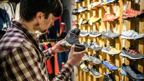 Kill i skobutik tittar på vandrarkänga